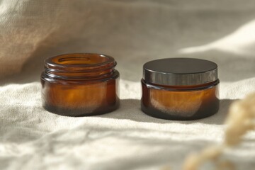 Poster - Amber Glass Jars for Cosmetics on Linen Fabric Close Up Still Life Product Photography Studio Shot Minimalist Style