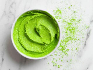 Poster - Overhead shot of vibrant green avocado dip in white bowl with matcha powder on marble surface for healthy eating concept