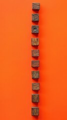 Poster - Minimalist composition of wooden cubes in a vertical line on a vibrant orange background studio shot flat lay