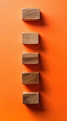 Poster - Wooden Blocks Arranged Vertically on Orange Background Flat Lay Minimalist Style Business Concept Education Toy