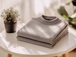 © Nontawat - Styled action shot of a neatly folded heather gray sweater on a table indoor space lifestyle photography