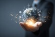 © hits - A person's hand gently cradles a glowing Earth, encircled by icons representing renewable energy sources and sustainability, set against a dark-grey backdrop