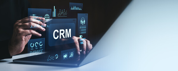 Poster - Businessperson using CRM software interface with digital analytics and charts on laptop screen in futuristic office environment at night.