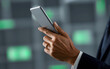 © Shemcko - Executive Hand Holding Small Tech Device in Modern Professional Setting
