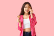 © Pixel-Shot - Young Asian woman with cookies on pink background