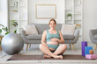 © Pixel-Shot - Sporty pregnant woman sitting on yoga mat at home