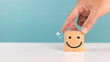 © sichon - Satisfaction, service rating and positive feedback concept. A man choose wooden cube with smile face emoticon indicate highest satisfaction