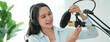 © Pormezz - content creator occupation concept. Woman adjusting microphone prepare to record podcast audio in-home office