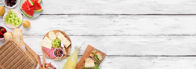 Poster - Summer picnic food corner border. Top view over a white wood banner background. Picnic basket, fruit, salad, sandwiches and snacks. Copy space.