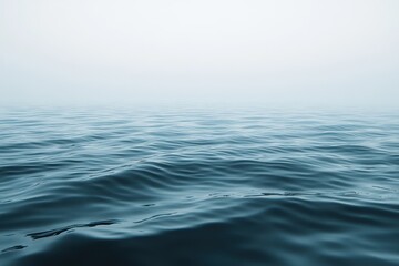 Poster - Expansive calm ocean waves under a foggy sky at dawn with subtle reflections creating a serene atmosphere