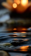 Poster - Water droplet cascading into pool, creating splash with soft light creating a warm inviting mood, surrounded by smooth stones.