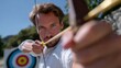 © Kenny - Focused caucasian adult male archer aiming at target outdoors