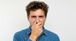 © Ura - Man Holding Nose Reacting to Strong Bad Smell Indoors