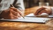 © Wararat - Close-up of hands reviewing family legal documents on wooden desk, pen and checklist beside, trust-building professional environment
