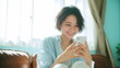 © Aruzimakon - 自宅でスマートフォンを使う笑顔の女性 #05