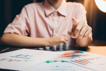 Poster - Businessperson Analyzing Data Trends and Giving Instructions with Graphs and Charts on a Desk in a Dimly Lit Office