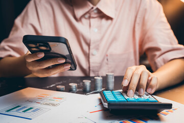 Poster - person in pink shirt using smartphone and calculator for financial analysis with charts and coins on