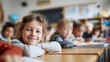 © TyliJura - happy smiling child student sitting at wooden desk in bright elementary school classroom education learning environment young blonde girl cheerful academic lesson