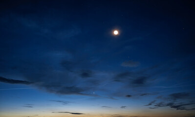 Wall Mural - a stunning transition from sunset to night with vibrant colors, scattered stars, and a bright celest