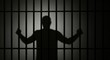 © Kristina - Shadow of a man standing behind prison bars. Concept of imprisonment and legal consequences. Symbolic image for criminal justice system.