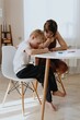 © looking2thesky - A loving mother and her son work together on homework at the kitchen table, symbolizing family support, education, and care. The scene highlights the importance of parental guidance