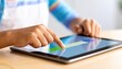 © M - Close-up of a hand interacting with a tablet screen, highlighting digital engagement and technology usage in a modern setting