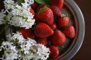 Aufkleber - A bowl filled with red strawberries and white flowers, showcasing the vibrant colors and delicate textures of the fruits and floral arrangement.