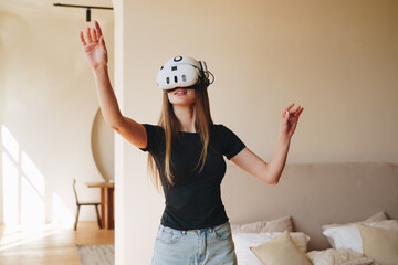 Poster - Virtual reality experience in a modern living room by a young woman engaged in immersive gameplay in the afternoon