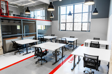 Poster - Modern workspace with multiple desks and bright natural light in a collaborative office environment