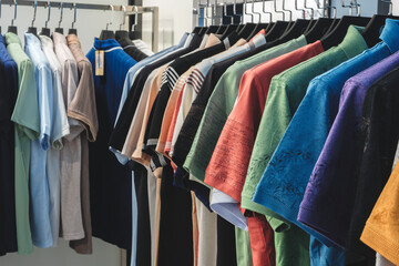 Poster - A rack of shirts with a variety of colors and styles. The shirts are hanging on a rack, and they are all different colors and styles.