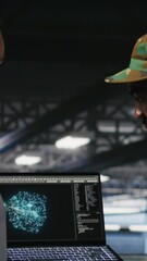 Poster - Vertical video Military personnel overseeing AI computing operations on laptop in high tech server facility. Army tech experts using artificial intelligence to oversee communication systems, camera B