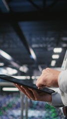 Poster - vertical video close up of server room worker checking code on tablet next to colleague reviewing ai