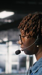 Poster - vertical video data center worker on industrial platform speaks in headset microphone while overseei