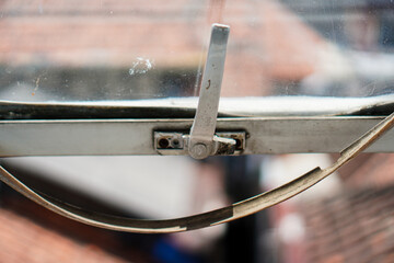 Poster - An abstract close-up image highlights an aged window mechanism with a metallic handle, showcasing textures and muted tones for backgrounds, architectural details, and industrial themes.