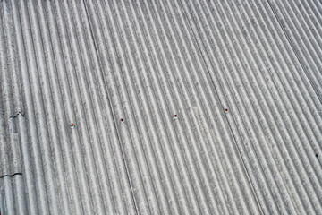 Poster - Textured grey roofing with repetitive ridge patterns creates visual interest. Minimal red fasteners provide contrast, enhancing the metallic aesthetic, while emphasizing simplicity and structure.