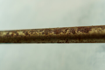 Poster - Close-up shot capturing the texture of a metal rod. The rod displays a weathered surface. Rust and corrosion patterns evoke a sense of age and decay against the blurred neutral background.