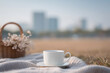 © Gordana - cozy coffee cup placed on picnic blanket surrounded by nature with soft morning light illuminating scene