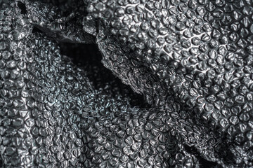 Poster - A close-up captures the sleek, silvery texture of bubble wrap, its surface crinkled and reflecting light, adding a modern and abstract touch. Ideal for backgrounds and overlay textures.