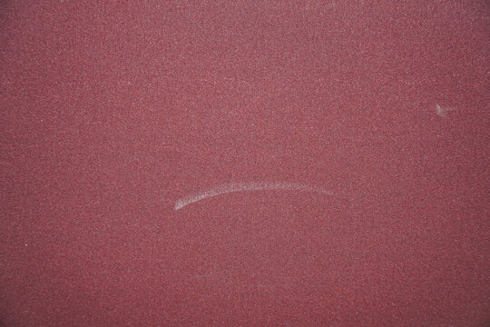 Detailed close-up showcasing a red, coarse texture with subtle tonal variations, perfect for backgrounds or design elements needing a textured and tactile quality. Ideal for creative projects.