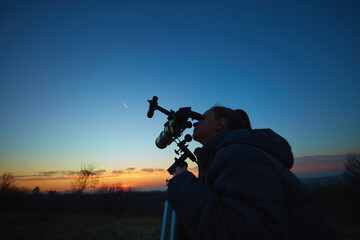 Wall Mural - amateur astronomer using telescope for watching stars, moon, planets and other celestial objects fro