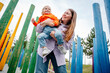 © Westend61 - Mother holding her daughter in a colorful playground