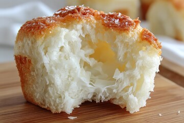 Poster - Freshly baked bread roll with a flaky crust and buttery center on a wooden board in a cozy kitchen