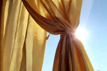 Aufkleber - Sunlight streaming through golden curtains on a bright day in a cozy room