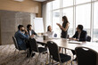 © fizkes - Group brainstorming. Focused multiracial businesspeople listen to businesswoman team leader setting startup task problem. Office staff engaged together in discussion think on strategy manager question