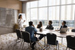 © fizkes - Professional development. Confident happy Asian lady businesswoman trainer coach expert talk lead corporate education event coaching program presentation for multiracial group trainees at boardroom