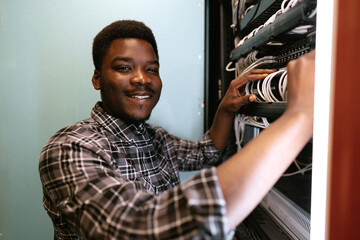 Poster - Technician organizes network cables in server room during daytime, ensuring efficient connectivity