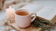© EIKOZ - Pastel Ceramic Mug with Herbal Tea beside Journal and Candle on Wooden Tray in Natural Morning Light