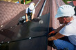 © anatoliy_gleb - Workers building solar panel system on rooftop of house. Two men installers in helmets installing photovoltaic solar module outdoors. Alternative, green and renewable energy generation concept.