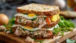 © Виктория Осипова - A delicious sandwich made with whole grain bread, filled with tuna, sliced tomatoes, boiled eggs, and fresh greens. Perfect for a quick meal or snack.