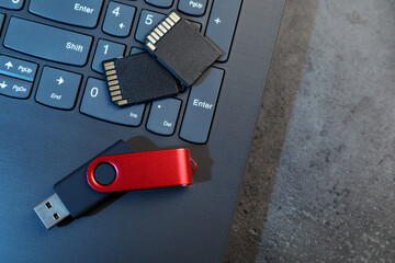 Poster - SD memory cards, USB flash drive and laptop on dark grey table, top view. Space for text